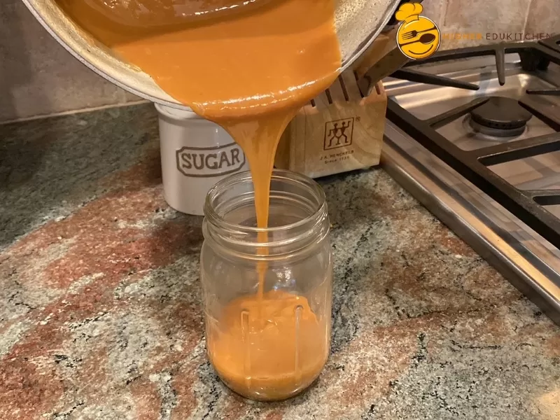 Cajeta being poured into a mason jar