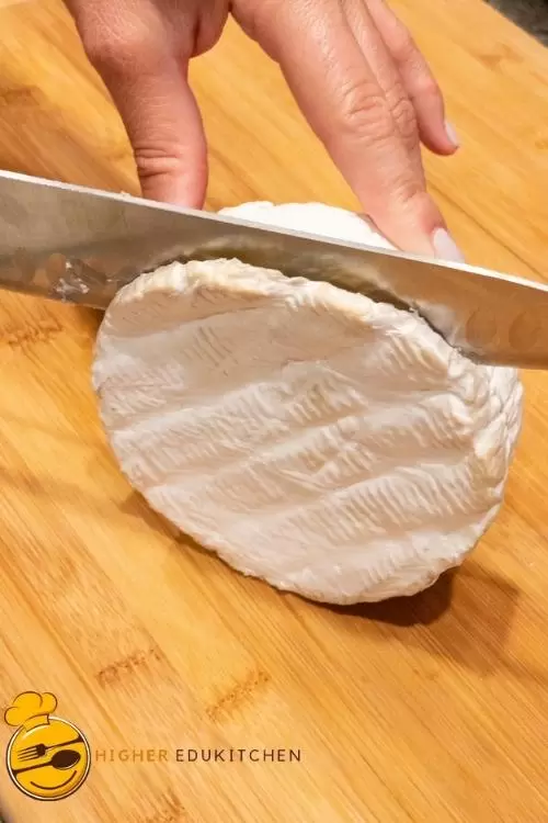 Slicing the top rind off brie cheese