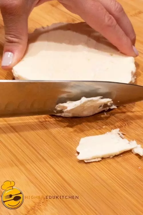 Slicing off the rind on the side of the brie