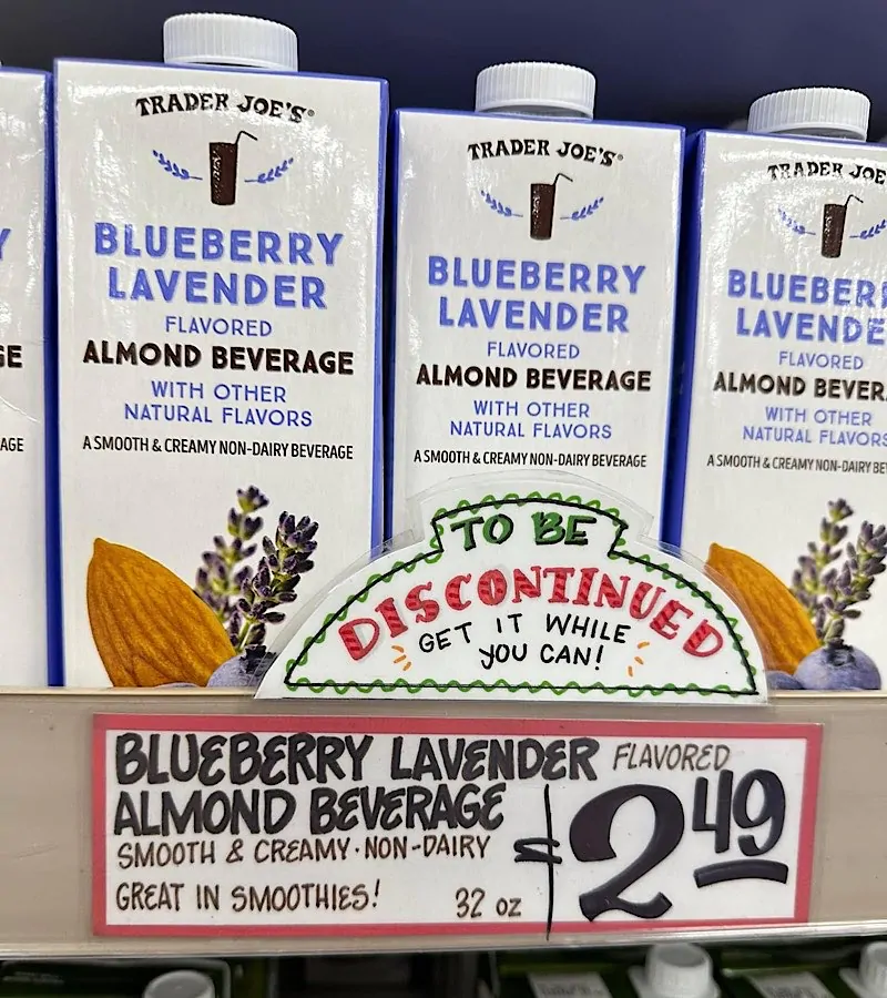 Trader Joes store display sign that reads Blueberry Lavender Almond Milk to be discontinued